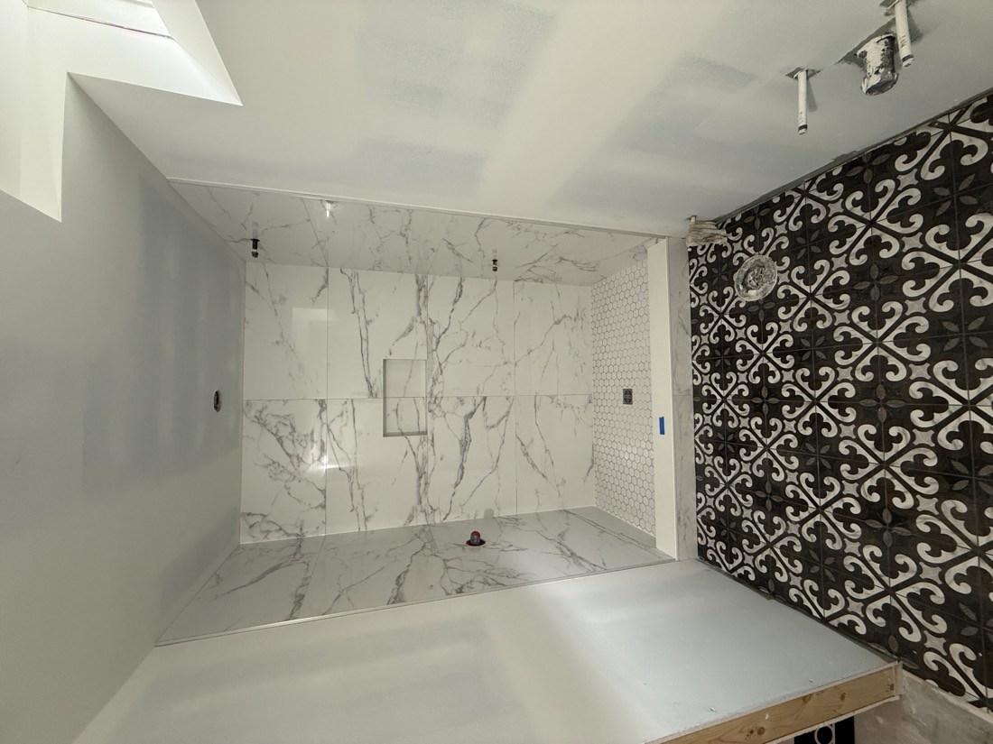 Marble-look shower with an encaustic patterned floor