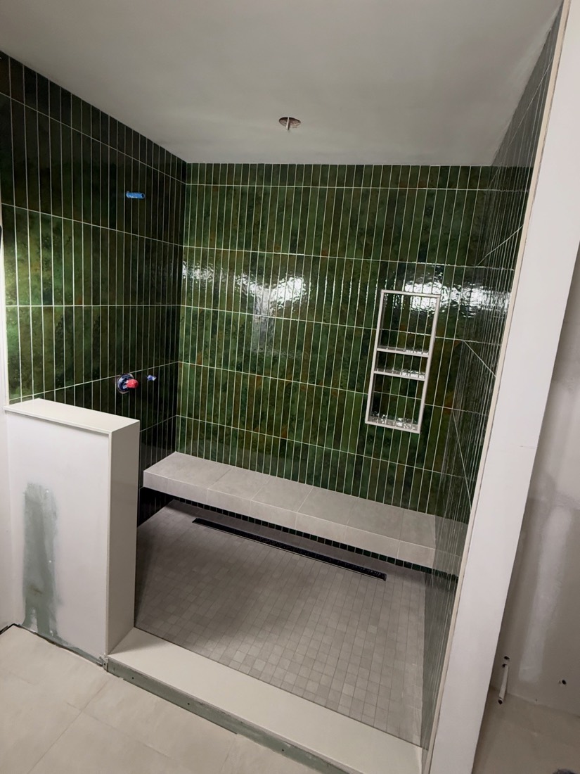 Emerald green gloss tile shower with a built-in bench