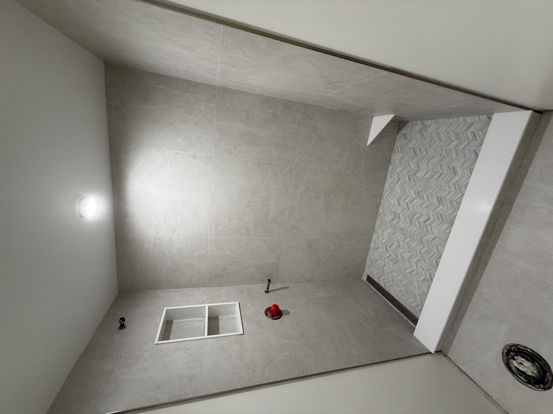 Large-format tile shower with a corner bench