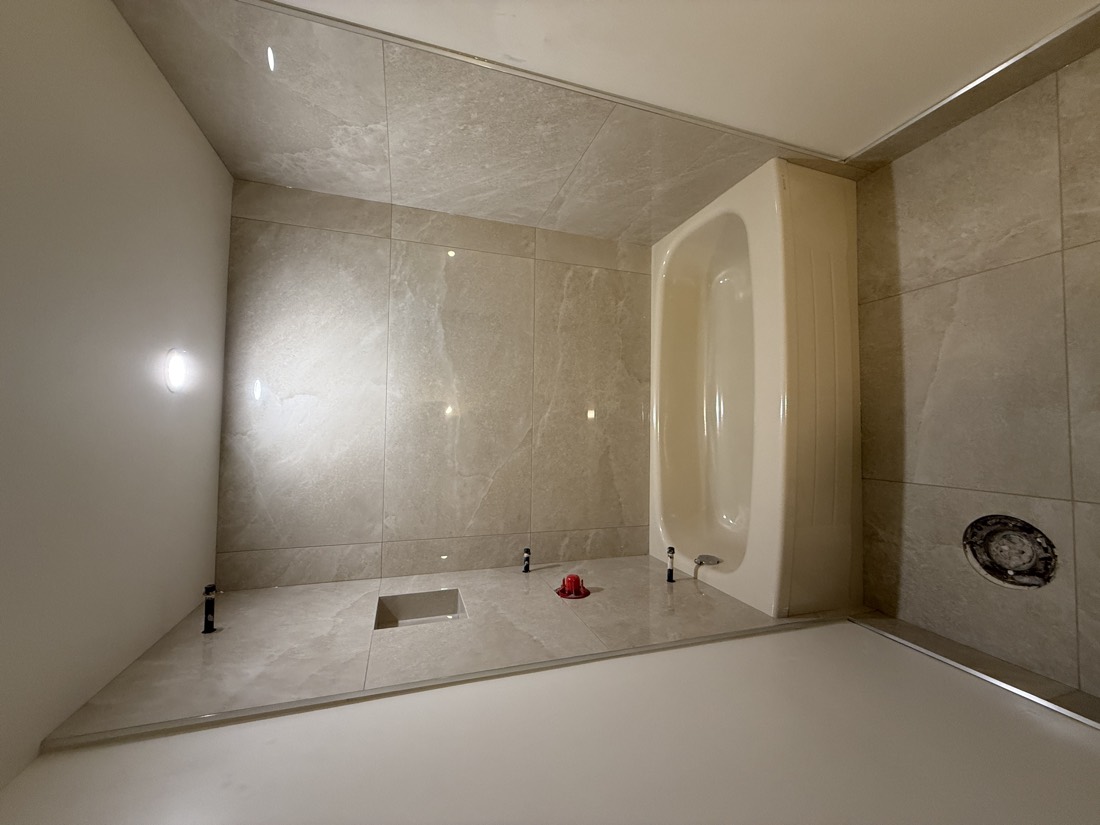 Cream tile shower with a corner tub